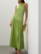 Woman wearing a pleated halter neck maxi dress made of slightly stretchy cotton-spandex blend