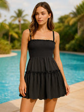 Woman wearing a smocked frill cami mini dress with tiered ruffles and slight stretch in light fabric