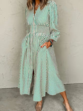 Woman wearing a Stripe V Neck Zip Front Cinched High Waist Midi Dress with pockets and smocked waist