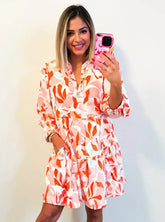Printed notched long sleeve dress with tiered design in 100% polyester, machine washable, no stretch, and not lined.