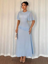 Woman wearing ruffled round neck flutter sleeve dress in 100% polyester with no stretch and machine washable fabric