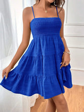 Woman wearing a smocked tiered cami dress with side slit made of polyester